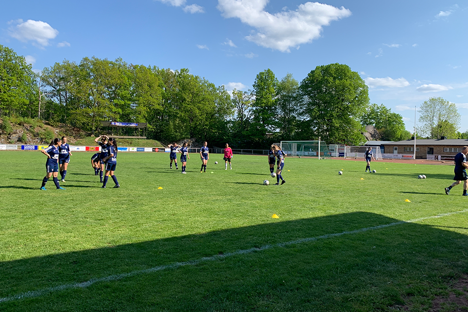 Fotbollsmatch, damlag, spelar match på en fotbollsplan