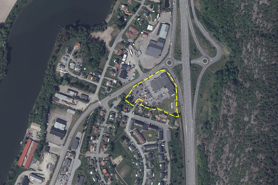 Flygbild över tätbebyggt område där ett område är inringat i gult
