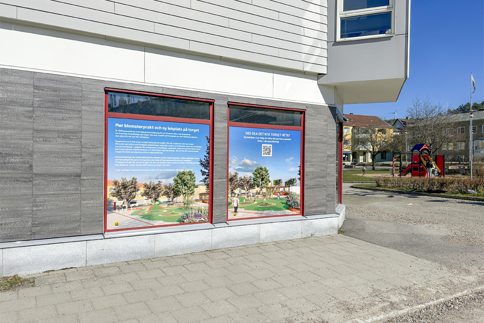 Bild på ett skyltfönster i närheten av torget i Lilla Edet. I skyltfönstret ser man bilder på hur torget kommer se ut när det är klart.