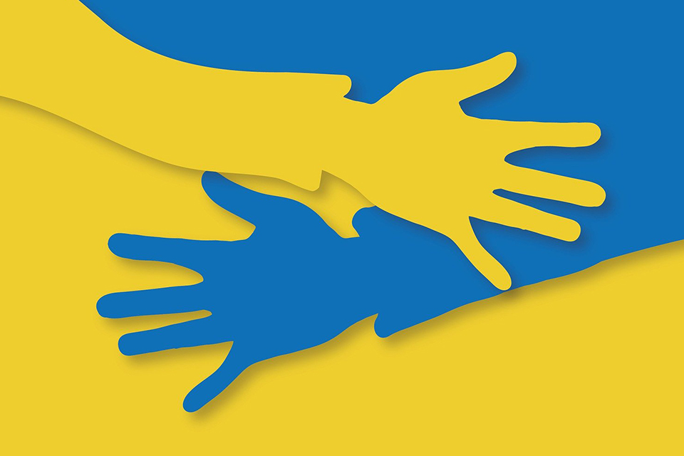 En gul och blå flagga där färgerna går ut i händer som håller om varandra