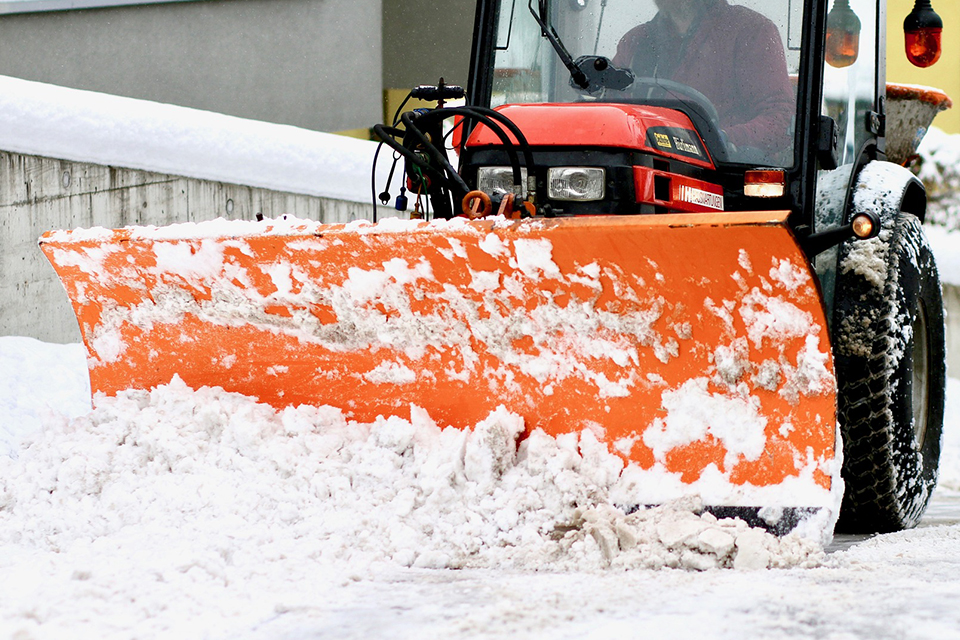 Bilden visar en traktor som plogar snö.