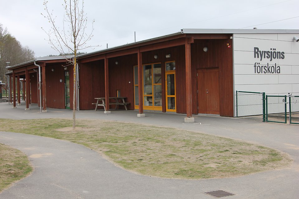 Röd och vit byggnad med texten Ryrsjöns förskola. 