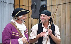 Två pirater samtalar och ler under en teaterpjäs
