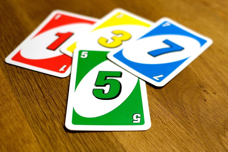 Fyra färgglada spelkort ligger på ett träbord
