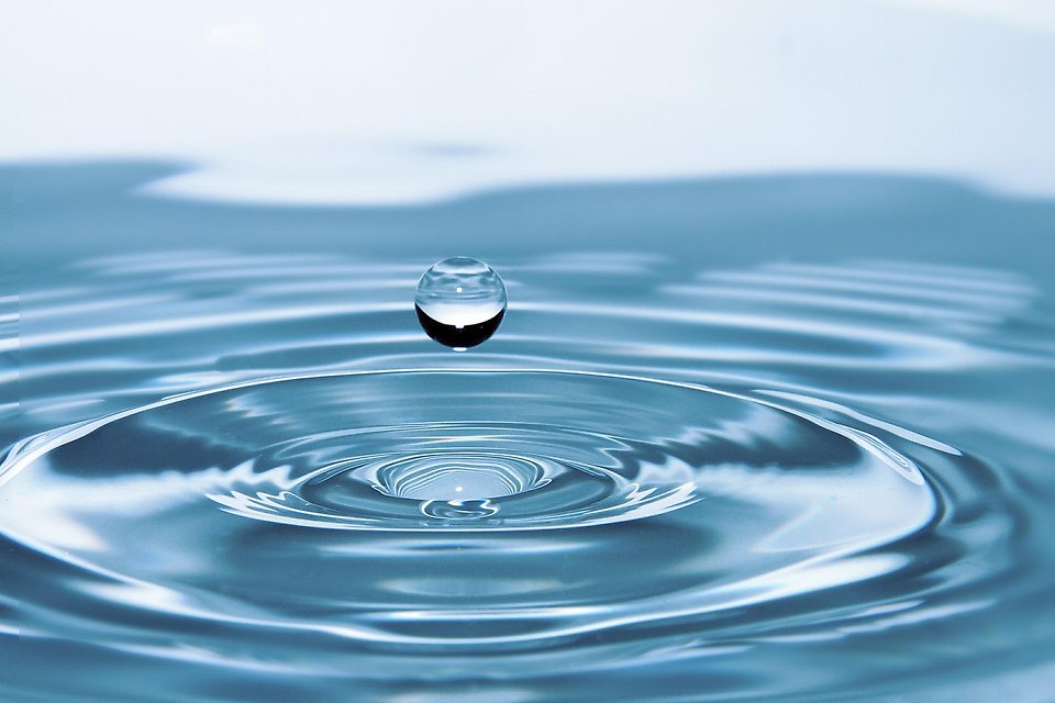 Närbild på vatten där en droppe skapar ringar på vattnet